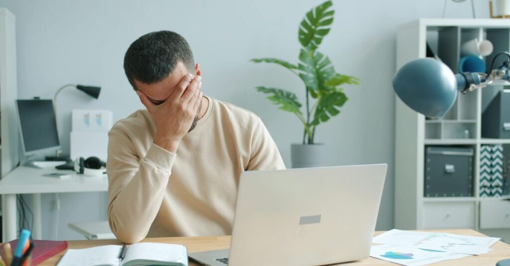 A frustrated user at a laptop experiencing ChatGPT Plus features not appearing after payment.